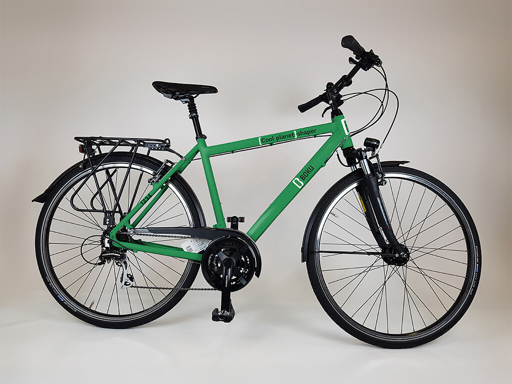 Ein Trekkingfahrrad in Seitenansicht mit grünem Rahmen im Design der BOKU, inklusive Logo und Slogan. 